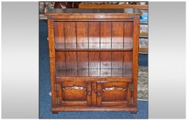 Oak Open Shelved Bookcase Unit with two small raised panelled cupboards below. Brass hinges, fine