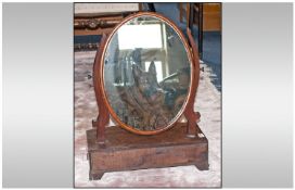 Antique Mahogany Bow Fronted Toilet Mirror with an oval shaped mirror supported by a pair of shaped