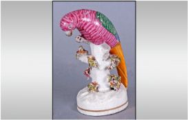 Staffordshire Parrot Figure, hand painted with a stylised feather pattern in bright pink, leaf