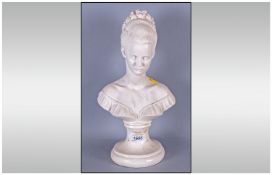 Plaster Bust Of A Young Girl with french hair style on a round pedestal base.