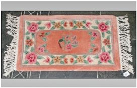 Small Wool Rug, light pink ground with floral decoration. 18 inches by 30 inches.