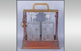 Two Bottle Oak Tantalus, comprising two square decanters with moulded hobnail decoration, fitted