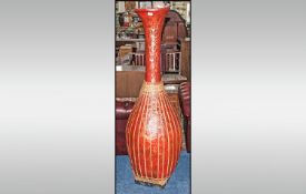 Tall Oriental Style Lacquered Red Vase of a tear drop shape. Decor in gold, depicting Onlaid with
