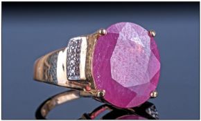 14ct Gold Ruby And Diamond Ring. The oval cut central Ruby, approximately 7cts with Diamond set