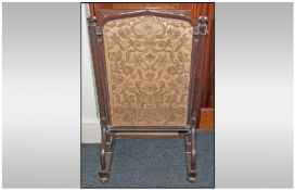 A Pugin Style Oak Fire Screen, with a sliding embroidered Tapestry screen centre. Pulled from the