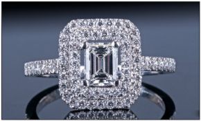 Platinum Diamond Dress Ring. Set with central emerald cut diamond surrounded by round modern