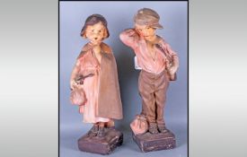 Pair of Coloured Plaster Figures, little girl with a violin and bag of belongings in her right hand