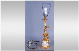 French Ormolu And Marble Lamp Base, depicting a putti sittings on an ormolu base above a white