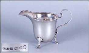 A Small Silver Helmet Shaped Cream Jug with scroll handle. Hallmark Birmingham 1937. 3`` in height.