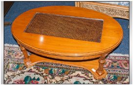 Walnut Covered Oval Shaped Coffee Table, glazed rattan centre on reeded scrolling arms & wings.