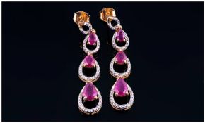 Ruby Triple Drop Earrings, each with three pear cut, graduated, rich red rubies set within three