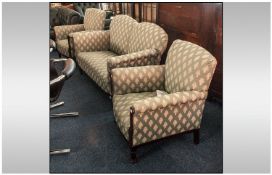 A Three Piece Upholstered Edwardian Parlour Suite dropped down arm on the settee. On a mahogany