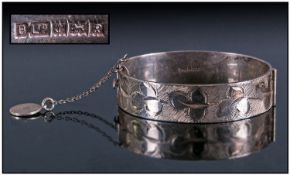 Silver Hinged Bangle With Safety Chain, fully hallmarked Birmingham. With engraved decoration. 40.