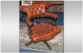 A Brown Leather Button Seat & Back Captains Chair on stained beech frame.