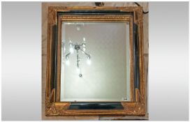 Wall Mirror, gilt and black frame with raised decoration. 26 x 22 inches.