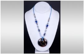 Murano Glass Pendant Necklace, the circular pendant with swirls of royal blue against a gold