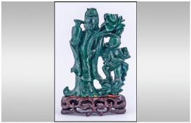 A Chinese Malakite Carving Of Quan Yin with a small boy holding a lotus flower & vase, with defects.