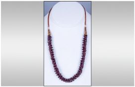 Free Form Ruby Coloured Cluster Bead Necklace, with woven cord and white metal fittings.