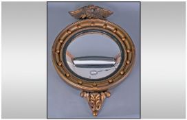 A Regency Style Convex Round Mirror, with an eagle carved finial. Height 25 inches.