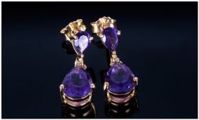 Amethyst Pear Drop Earrings, each earring comprising a pear cut, rich purple amethyst suspended