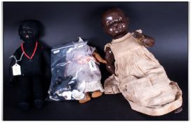 Black Girl Doll in a felt material, together with a black celluloid baby doll and a small bisque