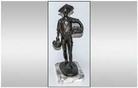 A 20th Century French Bronze Figure Of A Young Fisher Boy carrying baskets of fish. Raised on a