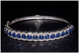 Tanzanite and Diamond Bangle, a row of oval cut tanzanites in a scalloped edge setting with diamond