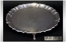 A Silver Circular Salver with piecrust border raised on four hoofed feet. Hallmark Birmingham 1929.