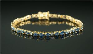 Blue Sapphire and White Sapphire Tennis Bracelet, rows of three oval cut blue sapphires interspaced