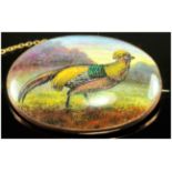 An Early 20th Century Oval Hand Painted Porcelain Brooch of a Gold Pheasant In a Woodland Setting.