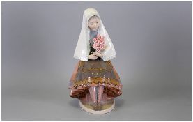 Lladro Figure of a Girl With Roses, seated, wearing a pink and grey tiered skirt, with matching