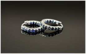 Blue Sapphire Hoop Earrings, the round cut sapphires set in a single row to the front of the hoop,