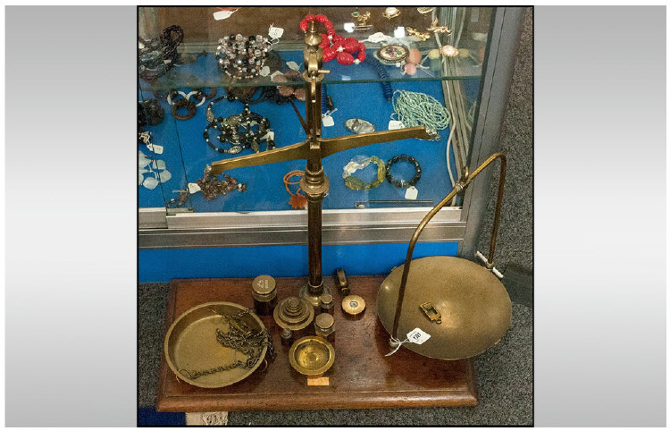 A Pair of Brass Avery Scales, on a wooden base, with brass weights.