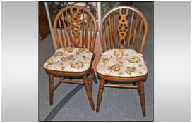 Pair Of Beech Stinted Wheel Stick Back Chairs with loose cottage decorated seat cushions.