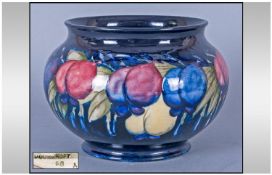 Moorcroft Bulbous Bowl, the pattern of plums in maroon, blue/purple and yellow with green foliage on