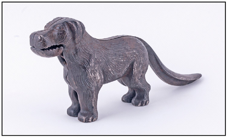 An Early 19th Century Cast Iron Nut Cracker In The Form Of A Dog. With a large tail. Height 4