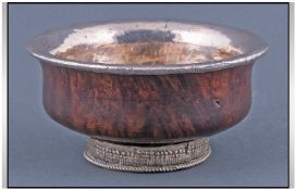 A Far Eastern Silvered Metal Mounted Wood Mazier with a metal mounted rim base. 19th Century.