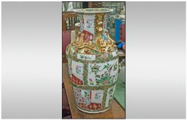 Large Canton Type Vase Depicting Chinese Courtly Scenes amongst flowers, with gilded handles &