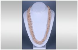 Two Multi Strand Necklaces. One in Coloured Beads, The Other Cream.