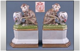 A Pair Of Oriental Pottery Figures Of Monkeys with vases fitted to a brass rim bases. Marks to base.