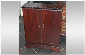 Modern Mahogany Finish CD Cabinet, hinged doors. 32 inches high and 25 by 8 inches deep.