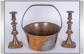 An Antique Brass Jam Pan with a pair of brass Candlesticks.