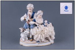 Unter Weiss Bach Porcelain Figural Group. Depicting a young man and woman seated, the man playing