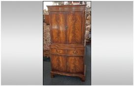 A Reproduction Feathered Mahogany Serpentine Fronted Cocktail Cabinet, with two cupboards with