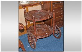 An Indian Rosewood Brass Inlaid Drinks Cart with two round pierced wood shelves with pushing