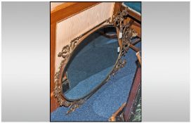 A Brass Framed Oval Shaped Mirror, in the rococo style. Length 39 inches.