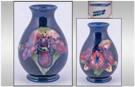 Moorcroft Small Vase. Orchids design on blue ground. Height 3.5 inches.