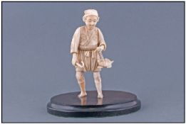 Japanese Early 19th Century Ivory Figure Of A Turtle Catcher, with a broken foot, raised on a wooden