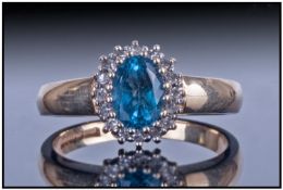 Ladies 9ct Gold Dress Ring, Set With An Oval Blue Topaz Surrounded By Round Brilliant Cut