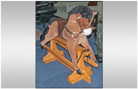 Merrythought Fabric Coloured Rocking Horse, with a leather saddle and metal stirrups. On a wood